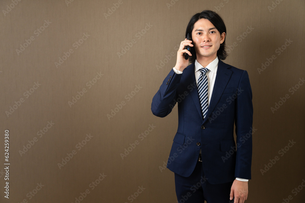 スマートフォンで通話する若いビジネスマン スマートフォンで通話する若いビジネスマン