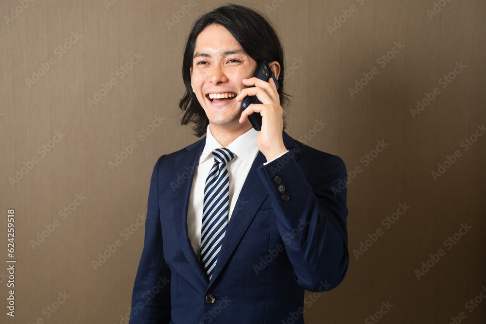 スマートフォンで通話する若いビジネスマン スマートフォンで通話する若いビジネスマン