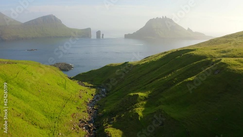 4k drone forward video (Ultra High Definition) of Faroe Islands and Tindholmur cliffs on background. Misty morning view of Vagar island, Denmark, Europe. Beauty of nature concept background..