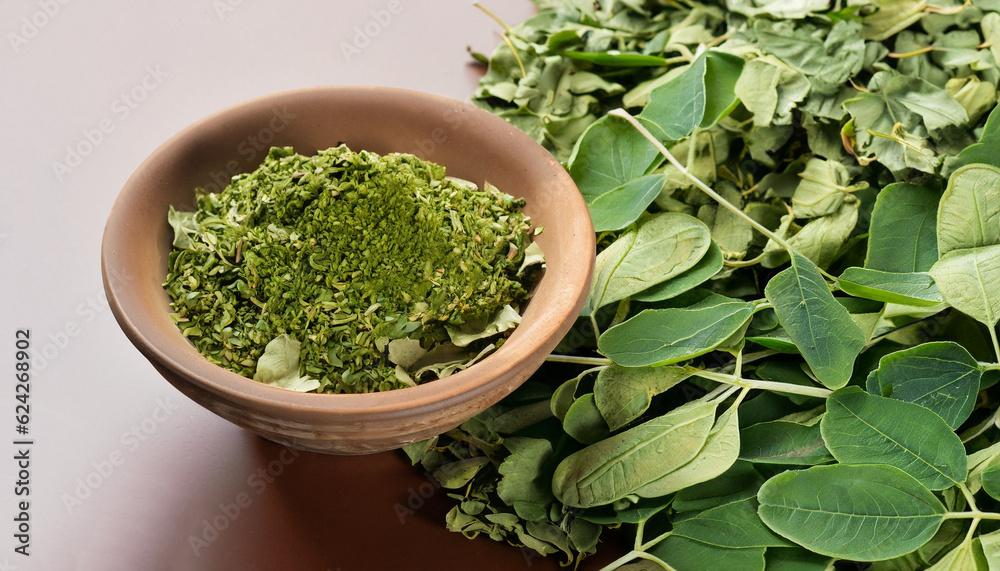 Green and dired moringa leaves with a small bowl Green and dired moringa leaves with a small bowl