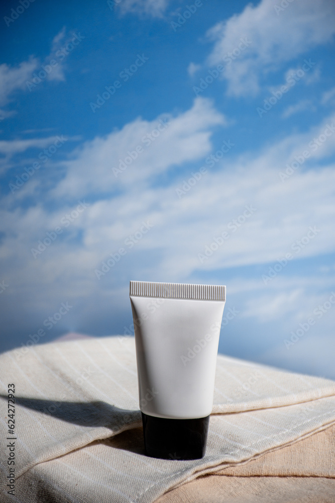 Cosmetic product in tube, bottle, lotion or serum on blue sky background. 