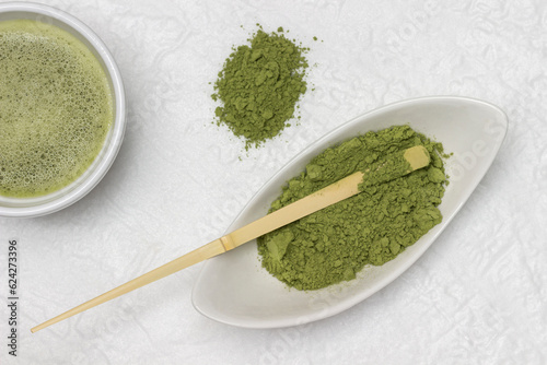 Matcha green tea powder and bamboo measuring spoon in a bowl. Matcha tea in a bowl.