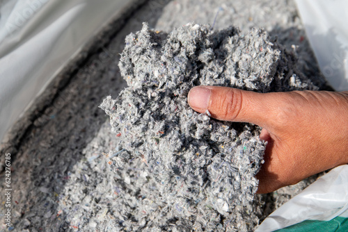 Cellulose insulation for walls and floors In hand. Recycled newsprint. Heat preservation and energy saving