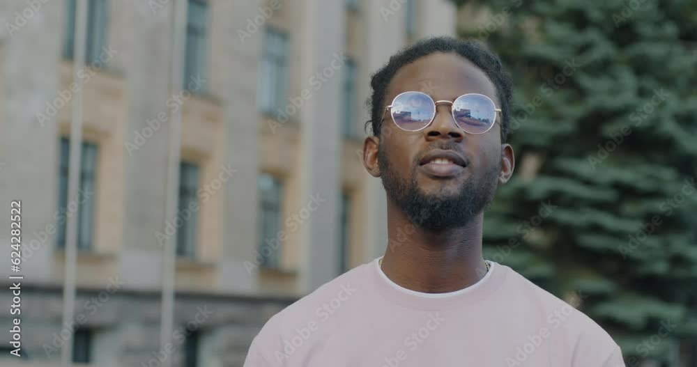 Slow motion portrait of happy African American man enjoying city view looking around standing in street alone. People and sightseeing concept. Slow motion portrait of happy African American man enjoying city view looking around standing in street alone. People and sightseeing concept.