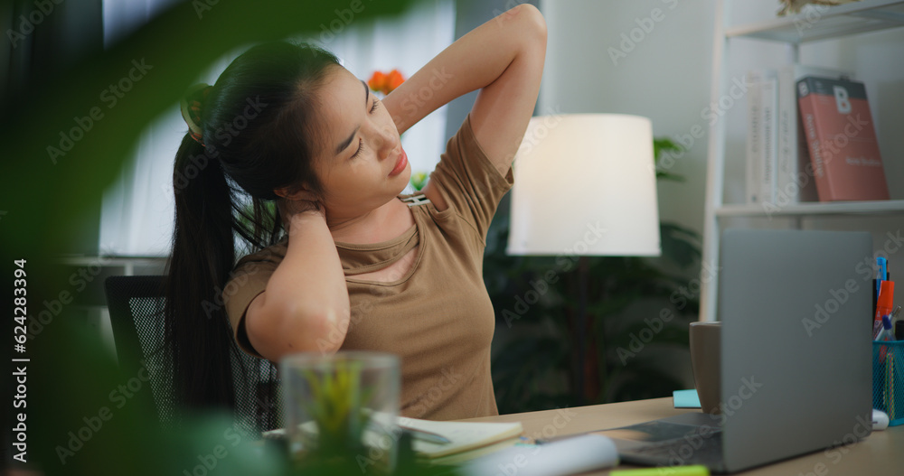 Tired young Asian woman working with a laptop on a desk