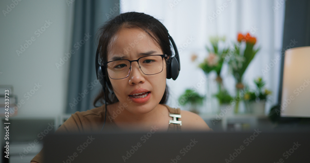 Young Asian woman wearing glasses using a laptop on a desk Young Asian woman wearing glasses using a laptop on a desk