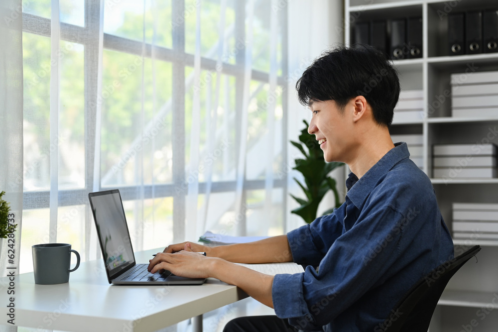 Asian man entrepreneur doing online data market analysis, using laptop in modern workplace Asian man entrepreneur doing online data market analysis, using laptop in modern workplace