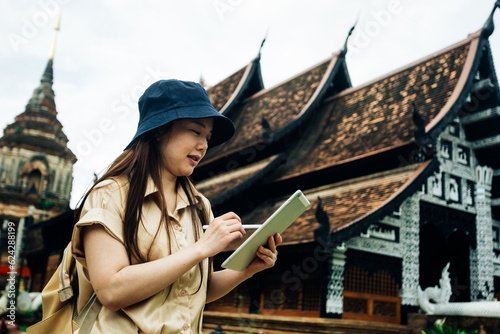 Asian traveller woman with tablet at ok moli temple in Chiang Mai province, Thailand © Chocheng channel
