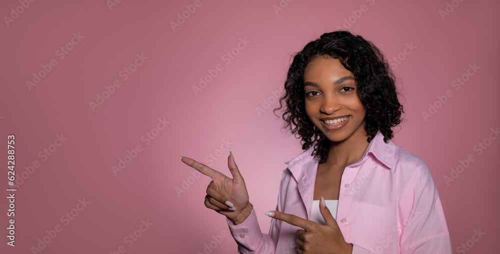 Smiling african american girl pointing at empty space. Copy space banner with back to school,valentines day,etc Smiling african american girl pointing at empty space. Copy space banner with back to school,valentines day,etc