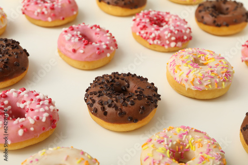 Chocolate, white and pink donuts on white background