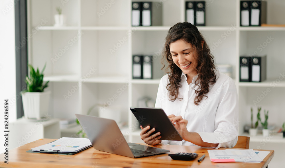 businesswoman working in the office with working notepad, tablet and laptop documents . businesswoman working in the office with working notepad, tablet and laptop documents .