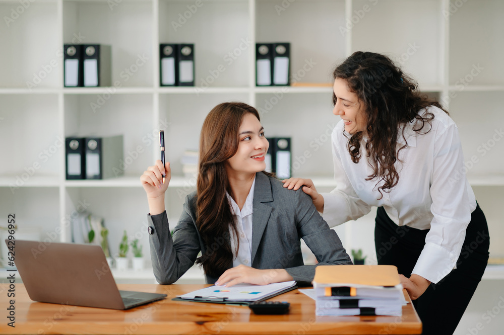 Two business workers talking on the smartphone and using laptop at the office. Two business workers talking on the smartphone and using laptop at the office.
