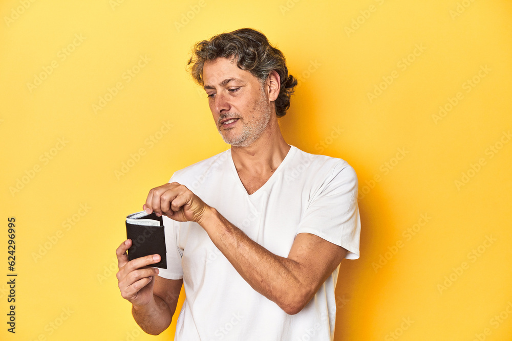 Middle-aged man holding a wallet full of dollars, denoting finance and wealth. Middle-aged man holding a wallet full of dollars, denoting finance and wealth.