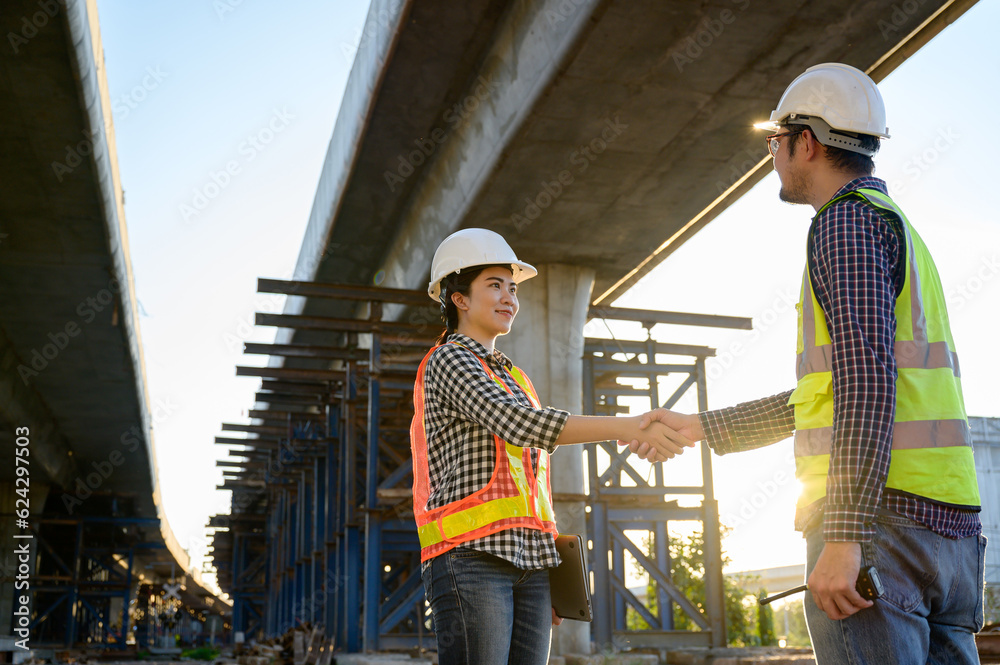 An engineer supervising the construction of new roads and inspecting the construction site shakes hands with a civil engineer