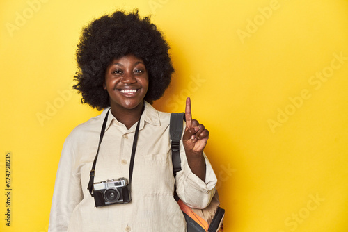 Stylish African-American woman with vintage camera Stylish African-American woman with vintage camera.showing number one with finger.