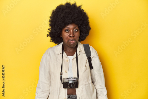 Stylish African-American woman with vintage camera Stylish African-American woman with vintage camera.shrugs shoulders and open eyes confused.