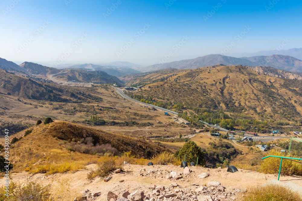 View from above. View from the Small Chimgan mountain to the valley and the highway. Landscapes of Uzbekistan.