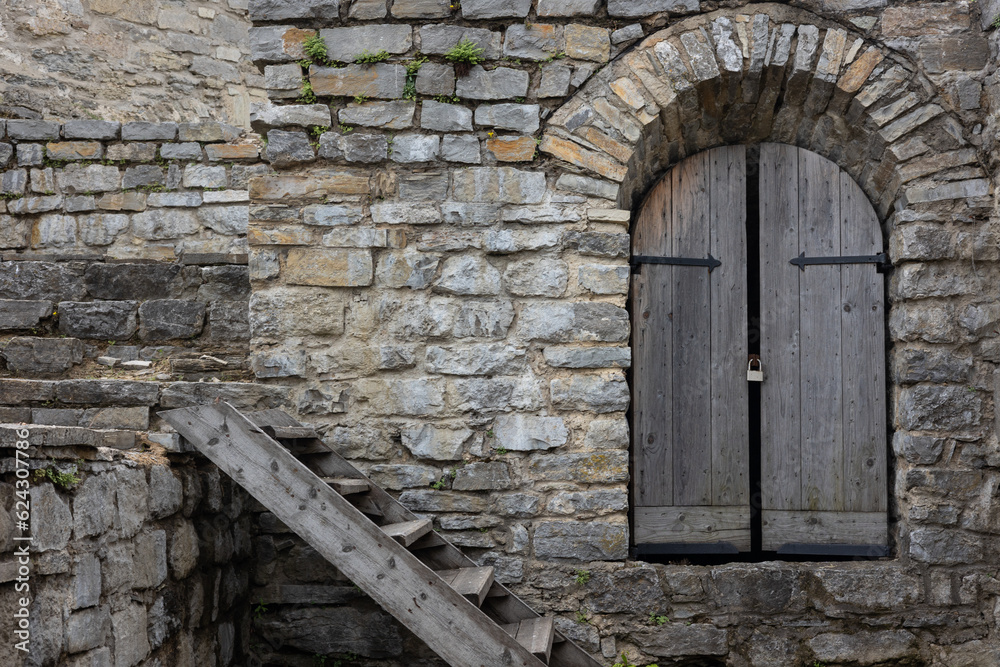 Old wooden door in stone wall