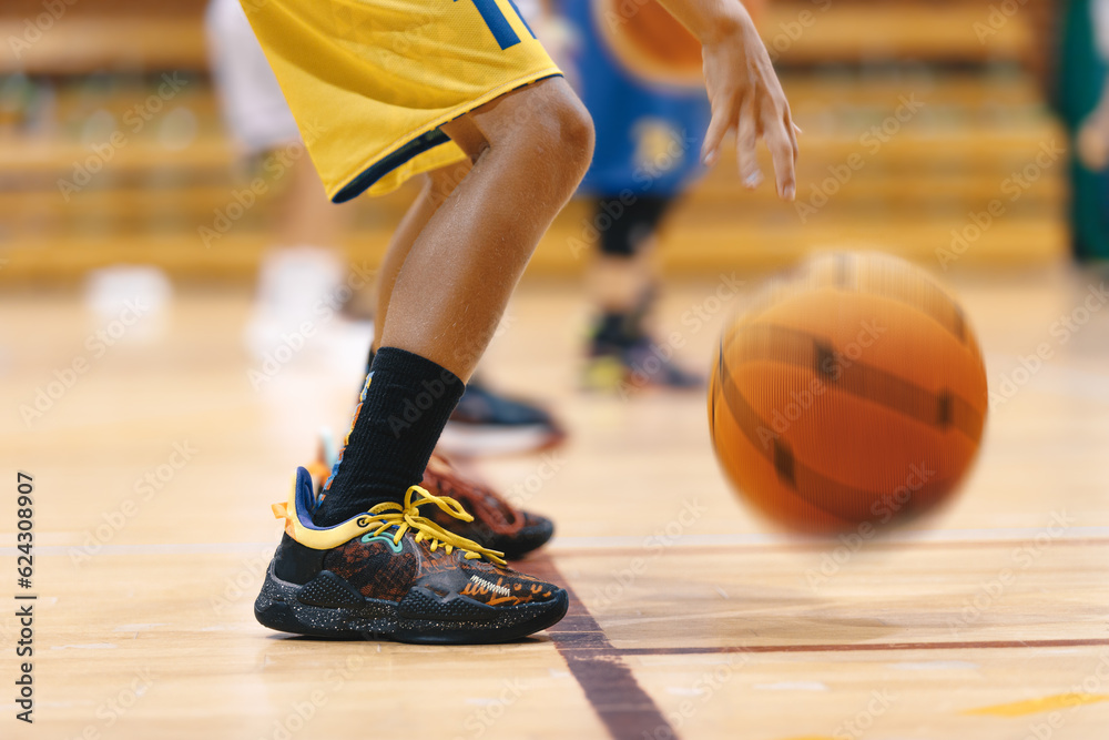 Fototapeta premium Young Boy's Intense Basketball Training on the Court of Champions. School Kids Showcasing Basketball Skills on Training Court. Youth Basketball Player Standing on Court Line and Bouncing Ball