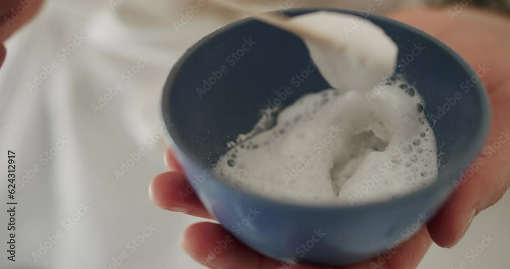The woman was mixing a bowl of foam mask, preparation for the cosmetic procedure for the care of the face. closeup. Skin care. Face renovation concept. The woman was mixing a bowl of foam mask, preparation for the cosmetic procedure for the care of the face. closeup. Skin care. Face renovation concept.