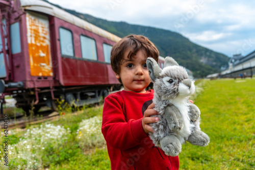 Child with a stuffed animal having fun in the old train station of Canfranc in the Pyrenees. Spain photo