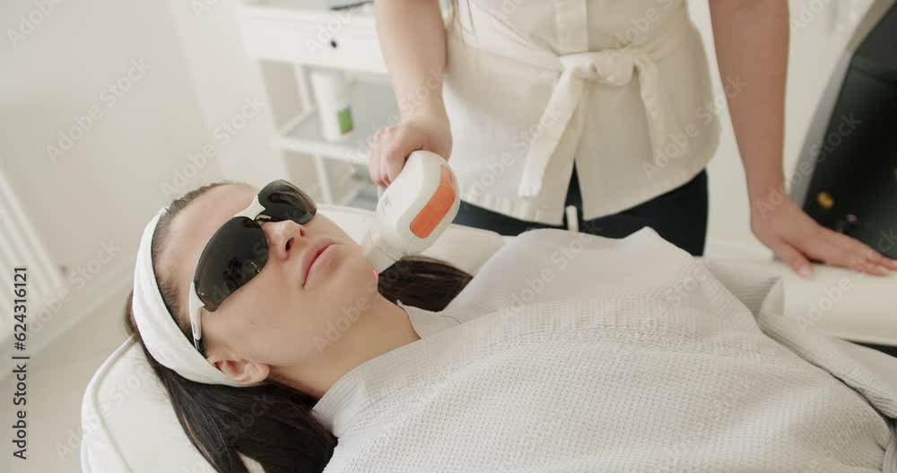 Beauty woman with protective glasses, aesthetic medicine is performing procedure. Beautician cosmetologist doing procedure fractional microneedle mesotherapy rejuvenation with laser technology. Beauty woman with protective glasses, aesthetic medicine is performing procedure. Beautician cosmetologist doing procedure fractional microneedle mesotherapy rejuvenation with laser technology.
