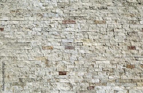 Old rough stone brick wall. Colors are white gray and brown. Background and texture.