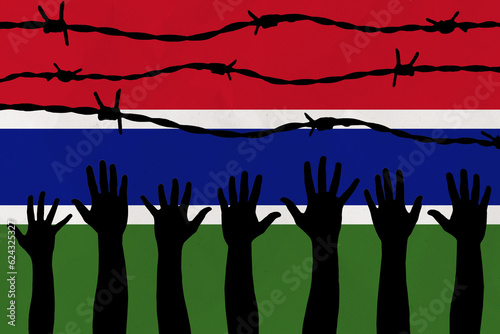 Gambia flag behind barbed wire fence. Group of people hands. Freedom and propaganda concept