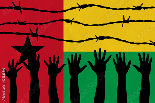 Guinea-Bissau flag behind barbed wire fence. Group of people hands. Freedom and propaganda concept