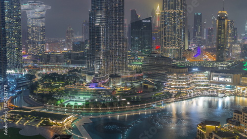 Skyscrapers rising above Dubai downtown day to night timelapse surrounded by modern buildings aerial top view © neiezhmakov