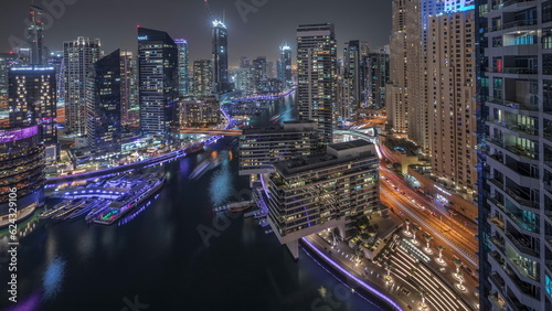 Aerial view to Dubai marina skyscrapers around canal with floating boats night timelapse © neiezhmakov