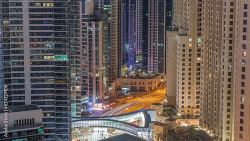 Overview to JBR and Dubai Marina skyline with modern high rise skyscrapers waterfront living apartments aerial all night timelapse