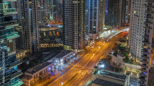 Aerial view on Dubai Marina skyscrapers and the most luxury yacht in harbor night timelapse, Dubai, United Arab Emirates