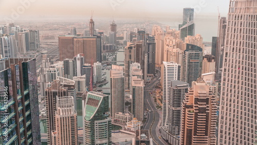 Skyline view of Dubai Marina showing canal surrounded by skyscrapers along shoreline night to day timelapse. DUBAI  UAE