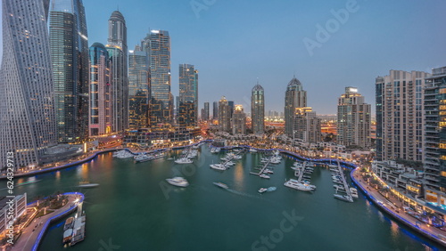 Dubai marina tallest skyscrapers and yachts in harbor aerial day to night timelapse.