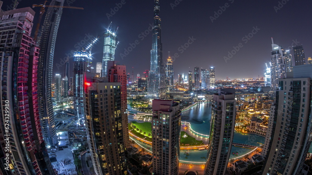 Panorama of Dubai Downtown cityscape with tallest skyscrapers around aerial all night timelapse.