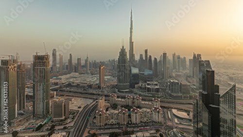 Panorama showing aerial view of tallest towers in Dubai Downtown skyline and highway timelapse.