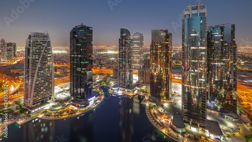 Tall residential buildings at JLT aerial day to night timelapse, part of the Dubai multi commodities centre mixed-use district. © neiezhmakov