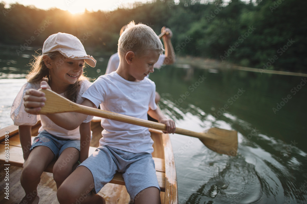 Fototapeta premium Brother and sister learning to paddle canoe