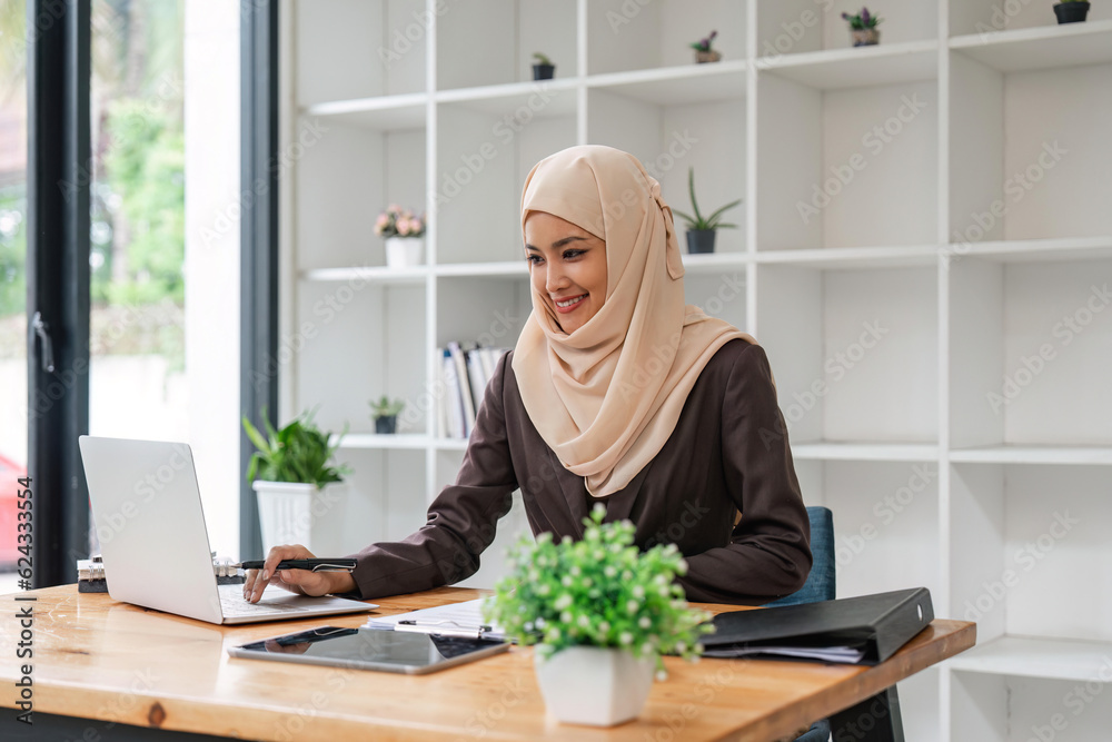 portrait of focused Muslim businesswoman working on computer in office portrait of focused Muslim businesswoman working on computer in office