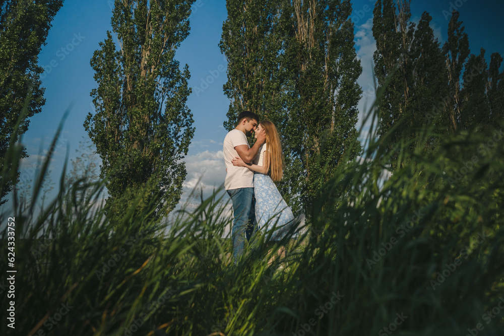 Far away view of a couple in love want to kiss on the background of nature. True love among lovers. Sincere emotions and love on the planet. Far away view of a couple in love want to kiss on the background of nature. True love among lovers. Sincere emotions and love on the planet.