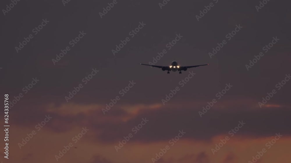 Jet passenger plane with headlights on approaching to land in the night sky. Airplane descending. Aircraft flies with headlights on. Airliner flies at dusk Jet passenger plane with headlights on approaching to land in the night sky. Airplane descending. Aircraft flies with headlights on. Airliner flies at dusk