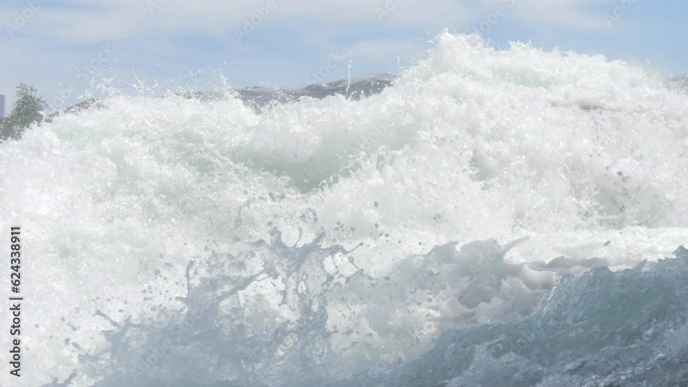 A large flow of water. Rhine Falls in slow motion. White healthy waves flow violently. The power of nature of water A large flow of water. Rhine Falls in slow motion. White healthy waves flow violently. The power of nature of water