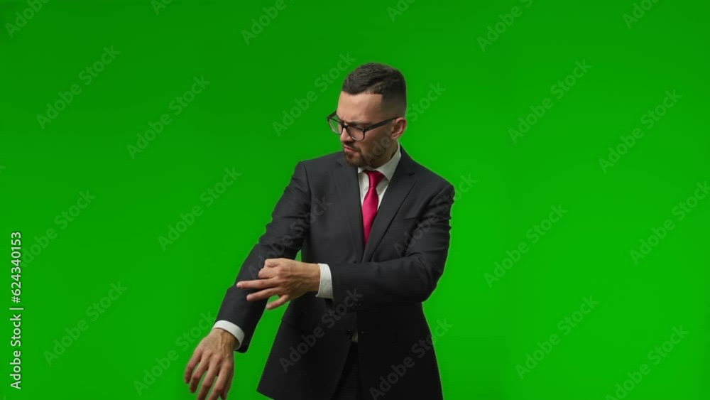 Handsome young businessman with a beard in a black expensive shakes off a speck of dust from his shoulder Handsome young businessman with a beard in a black expensive shakes off a speck of dust from his shoulder