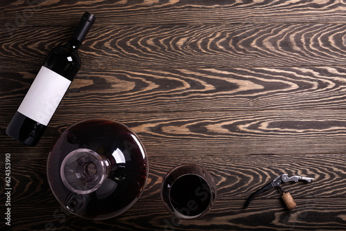 Decanter, glass and bottle with red wine on wooden background. Flat lay