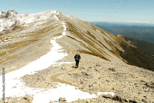 a figure hike on the summit of a snowy mountain in New Zealand