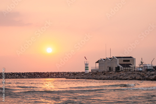 Quiet sunset shore scene with a lighthouse. Minimalist landscape. Agean Sea, Turkey, Kusadasi. © Dumitru