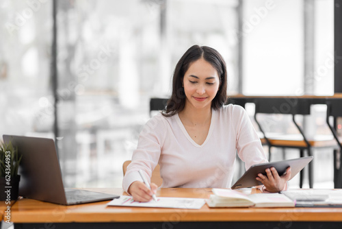 Young asian woman using laptop computer for business studying, watch online virtual webinar training meeting, video call. Focused asian woman or Latin business woman work in office, copy space. 