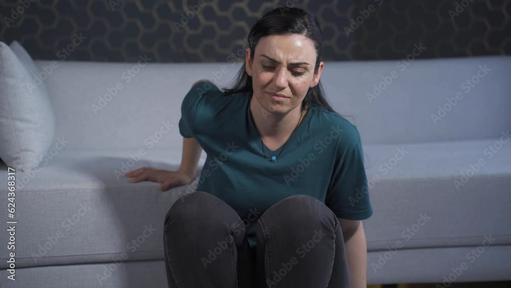 Depressed woman. It sits by the wall. Depressed woman. It sits by the wall.
