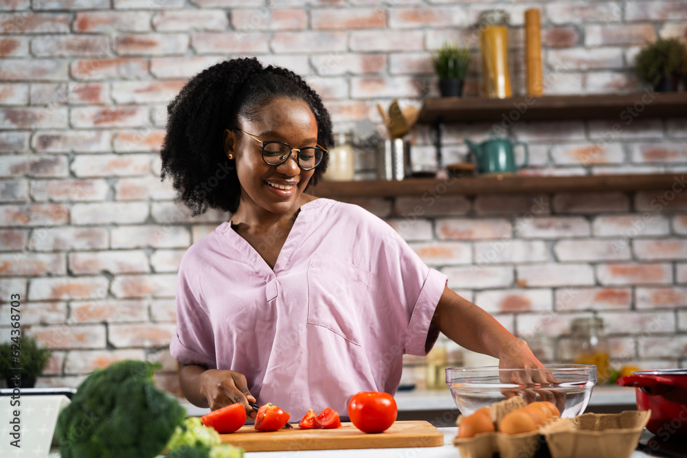 Young woman in kitchen. Beautiful woman making salad.